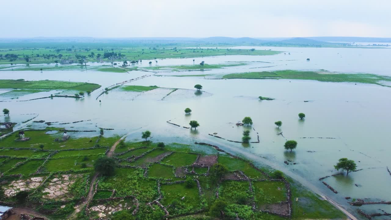 Aerial shot of a flooded river submerging a village in water in rural india
