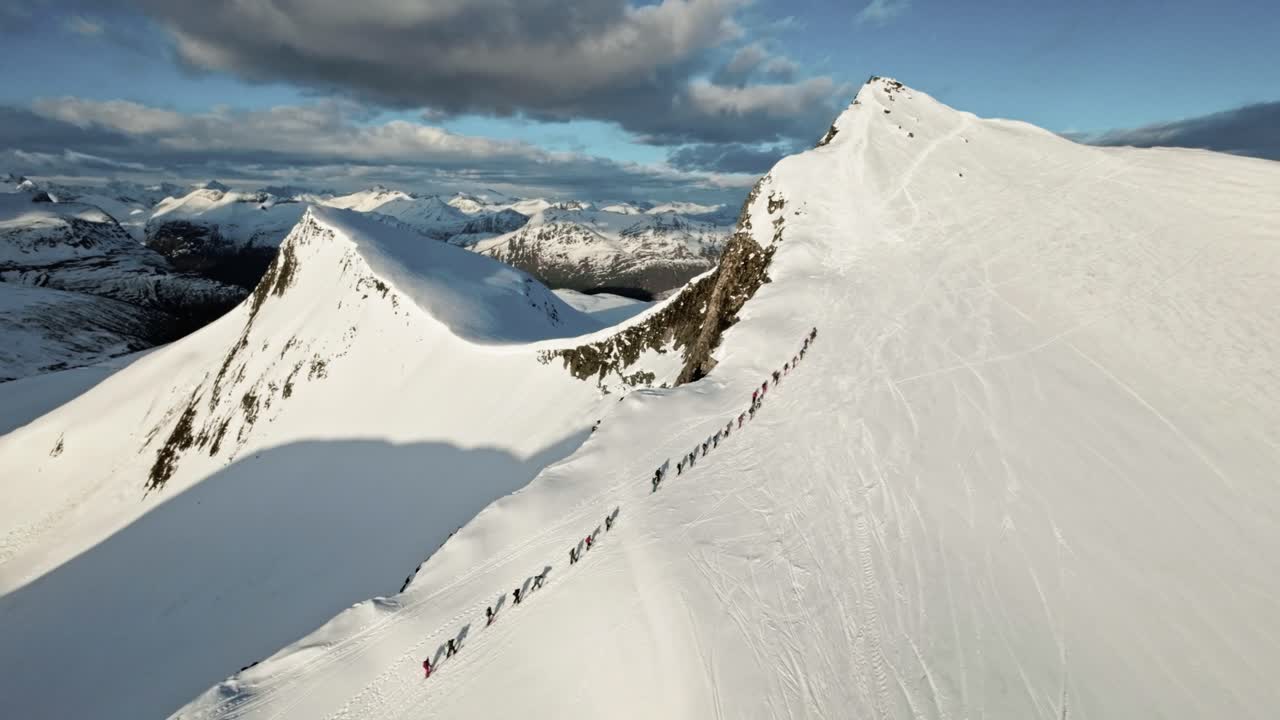 un grupo masivo de personas escalando una montaña nevada para esquiar, vista aérea
