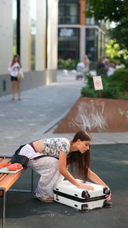 woman packing suitcase in city park