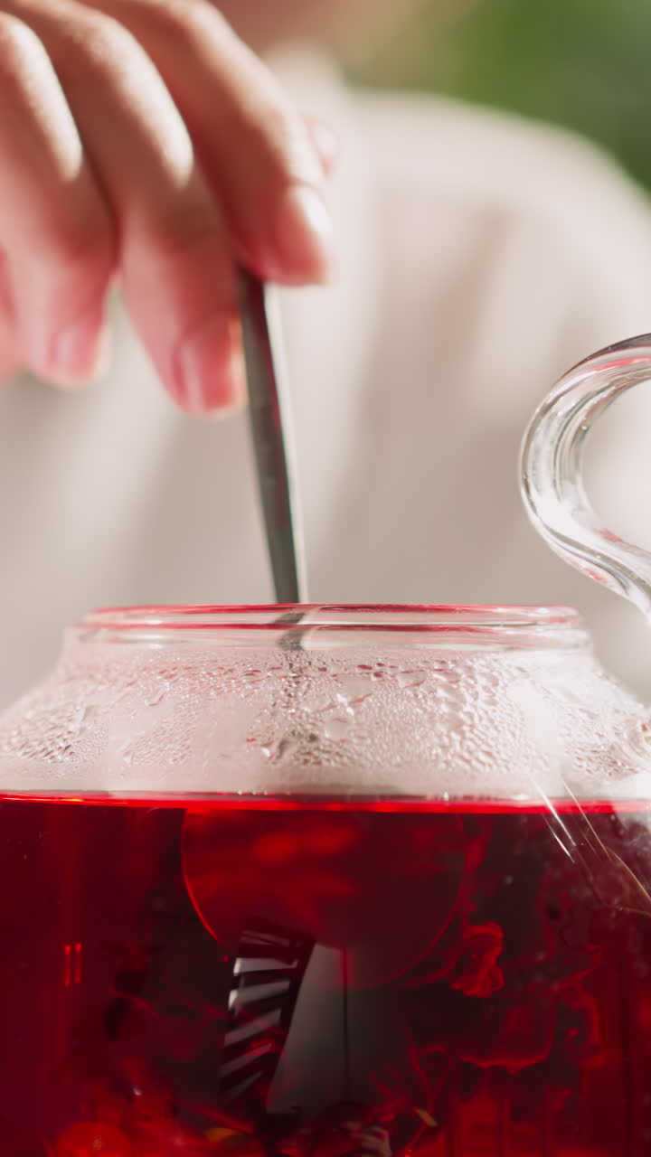 한 여인이 컵과 함께 차병에 히비스쿠스 음료를 니다. 한 여인이 식탁에서 아침 식사로 향기있는 허브 차를 습니다. 아침 의식에서 약혼합니다.