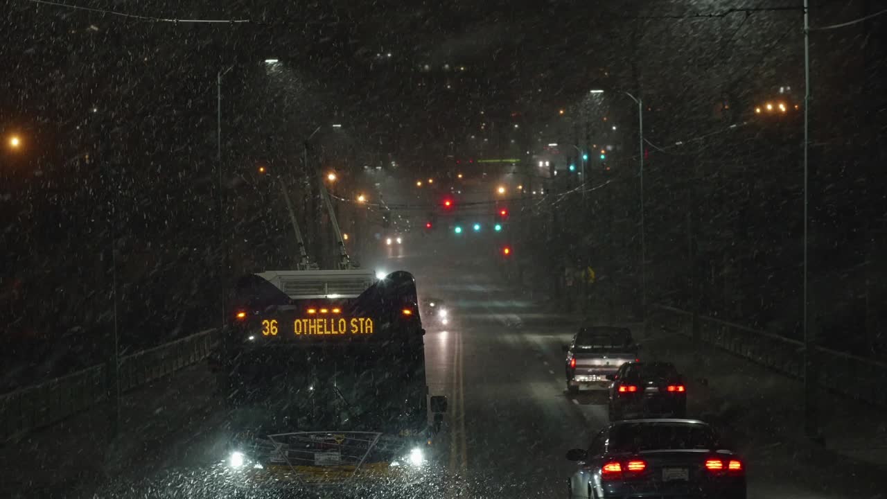 시애틀, wa-2-17: 밤에는 거리에 많은 눈이 내리고 시내 버스가 지나갑니다.