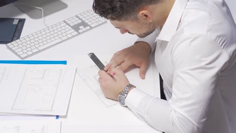 el arquitecto organiza y renueva los dibujos de perspectiva en su escritorio en la oficina de arquitectura.