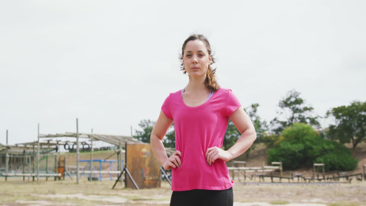mujer caucásica mirando a la cámara en el campo de entrenamiento