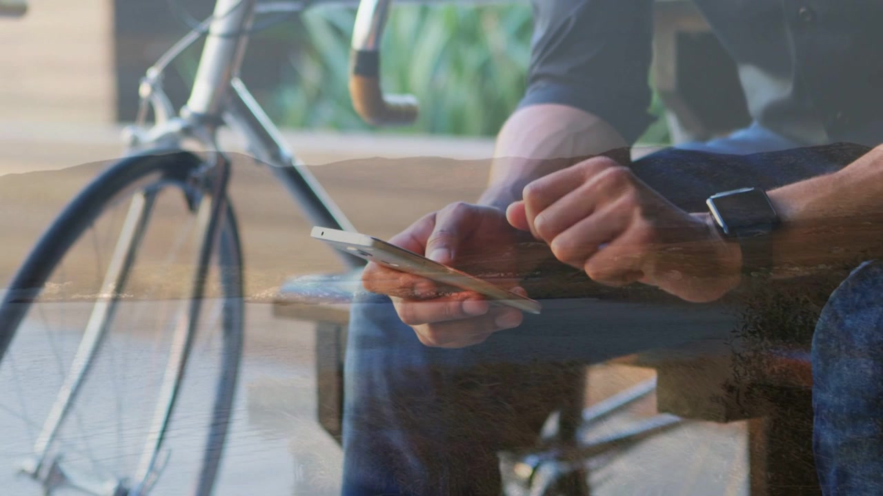 Uomo seduto su una panchina che tocca il telefono, attivando avvisi animati sullo smartwatch per informazioni sul tragitto tecnologico