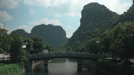 man crossing the bridge in trang an vietnam