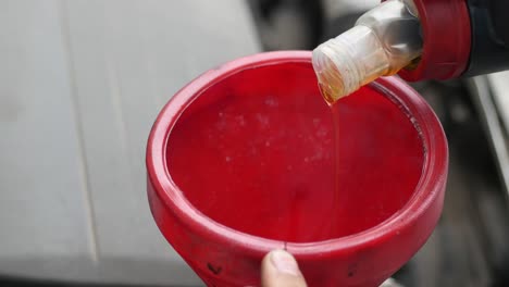 pouring engine oil into a car