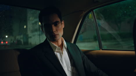 stylish boss sitting auto evening closeup. serious businessman looking camera