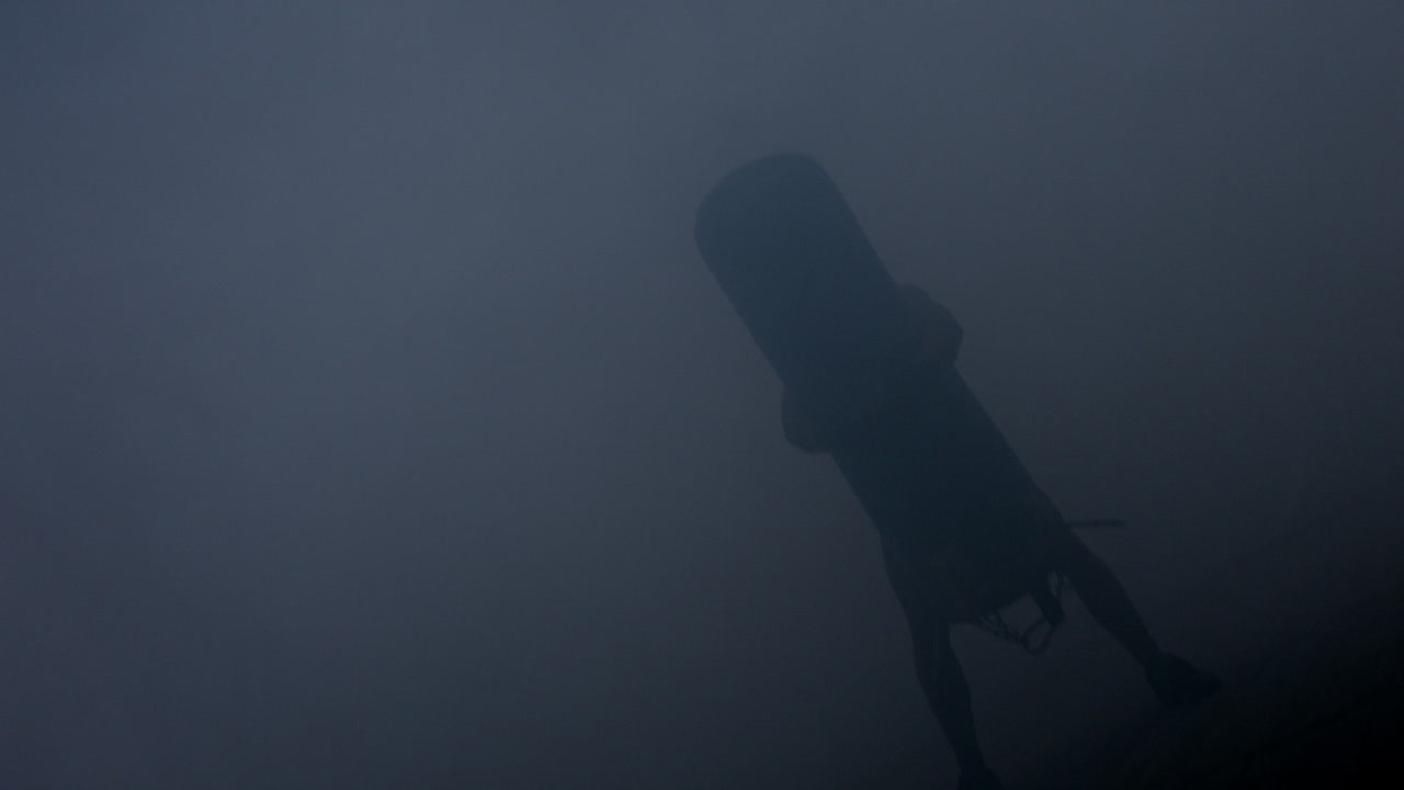 la silueta del boxeador de patada es un saco de boxeo. el entrenamiento del boxeador mma con saco de boxeo