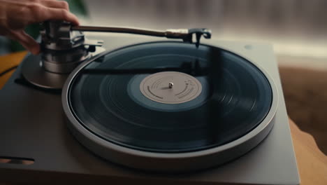 hands operating a turntable with a vinyl record
