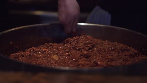 el chef está mezclando frijoles en la enorme olla del restaurante