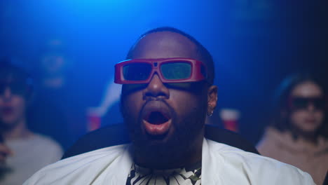 african guy eating popcorn at 3d cinema