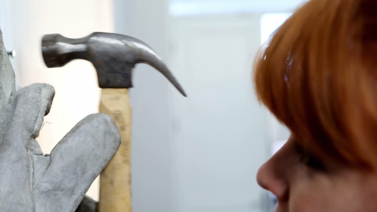 mujer trabajando con martillo en casa 4k