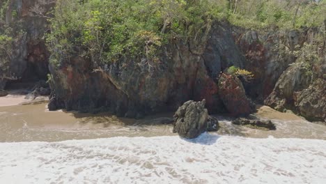 olas espumosas salpicando en la escarpada orilla de la playa el valle playa en la península de samana de la república dominicana