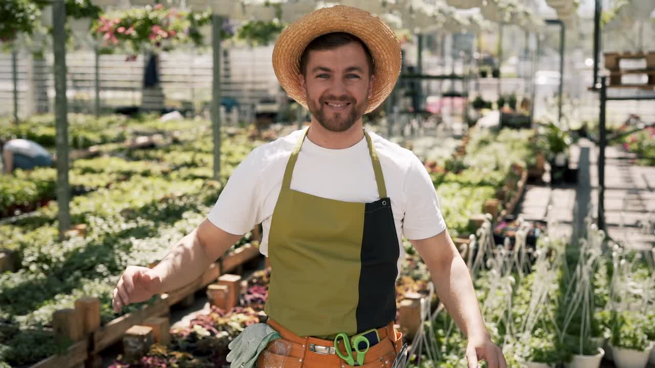 retrato de un joven jardinero con delantal y sombrero mirando a la cámara