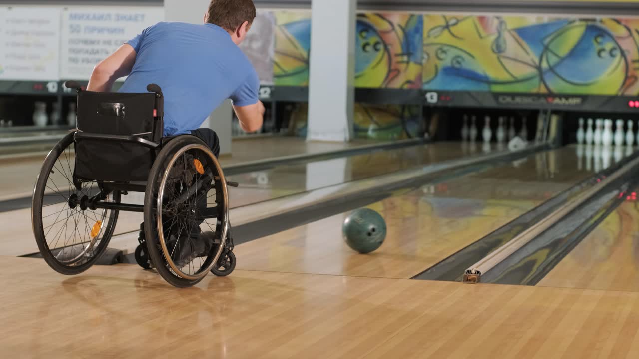 Due giovani disabili in sedia a rotelle che giocano a bowling nel club