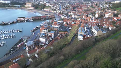 Vorwärts-Drohnenaufnahme-Einer-überfüllten-Stadt-Scarborough-Im-Norden-Von-Yorkshire-In-Der-Nähe-Eines-Meeres-Mit-Einigen-Booten-Tagsüber-In-England,-Großbritannien