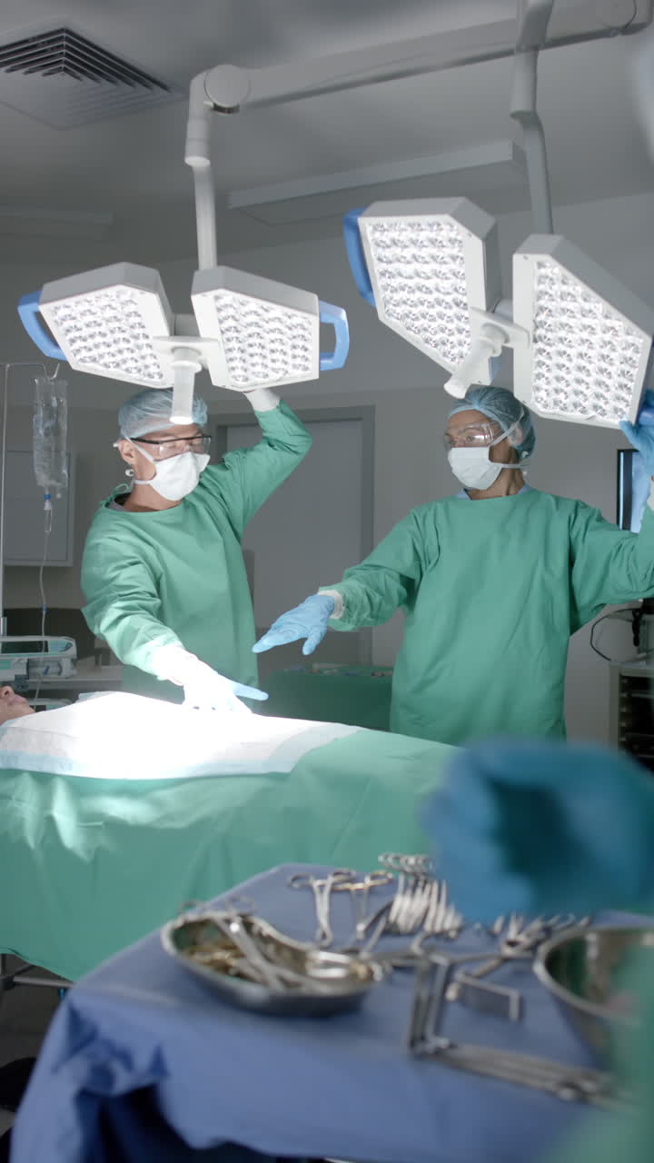 Vertical video of diverse surgeons with face masks preparing surgery in slow motion