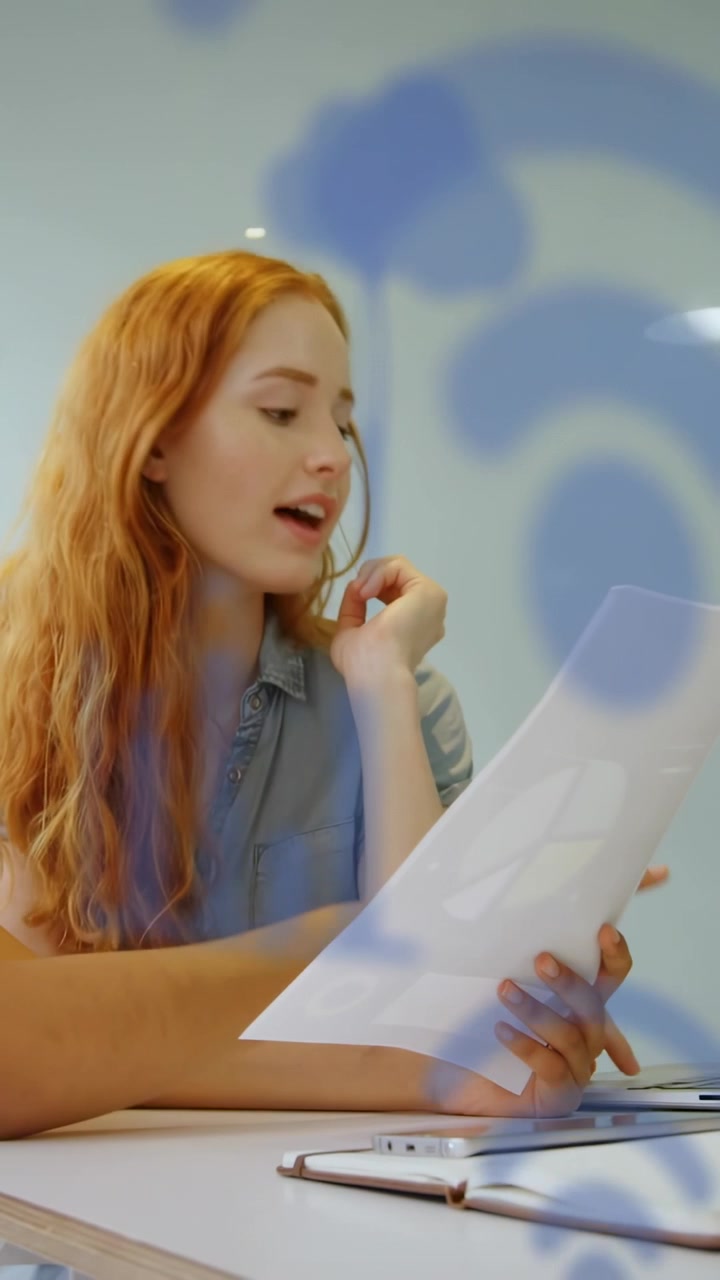 Video verticale: Un collega che consegna un documento a una donna che legge e indica per affari, con una sovrapposizione blu che si muove con la carta.