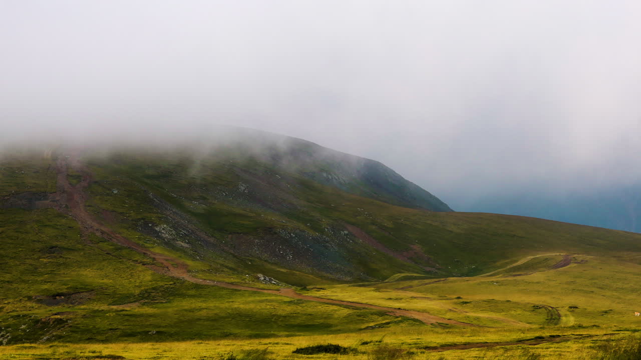 Ampia vista montana con panoramica a destra mentre la nebbia attraversa la cima Transalpina.
