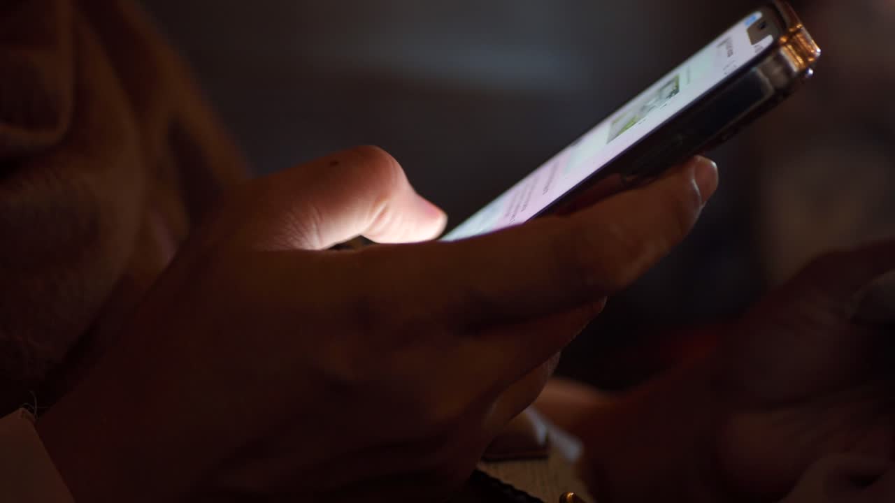 persona que utiliza un teléfono inteligente por la noche