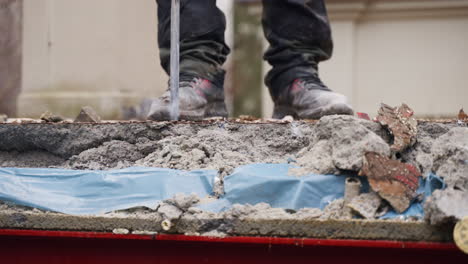 un trabajador en un sitio de construcción demoliendo asfalto o pavimento de hormigón con una vista frontal de martillo neumático