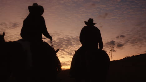 Vier-Cowboys-Reiten-In-Die-Silhouette-Der-Aufgehenden-Sonne