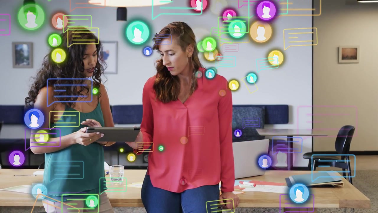 Mulher à esquerda tocando no tablet, mulher apontando, revisando plano de marketing, com balões de chat se multiplicando.