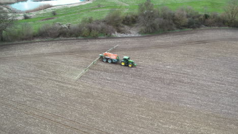 un tractor rociando fertilizante en un campo