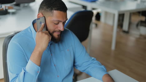 Smiling-bearded-brunet-talking-on-smartphone.