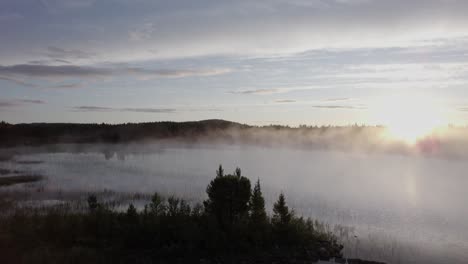 eerie morning sunrise mist over tranquil forest lake norway landscape drone