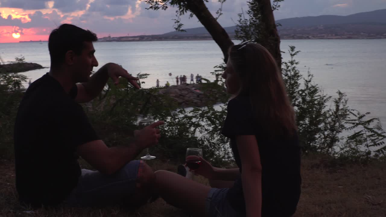 커플 이 바가 에서 만적 인 일몰 을 즐기고 있다