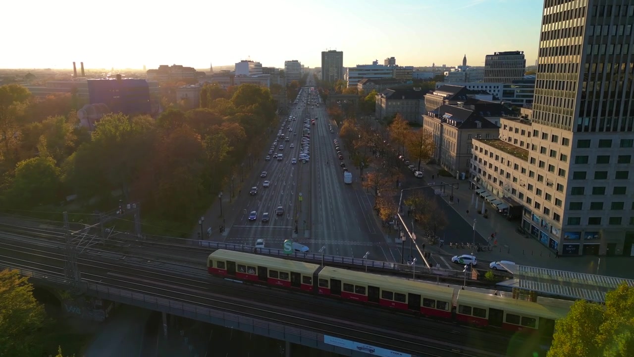 Vlak projíždějící barevným podzimním listím parku Tiergarten v Berlíně, Německo, během západu slunce. Nádherný letecký časosběr s efektem speed ramp a hyper motion.