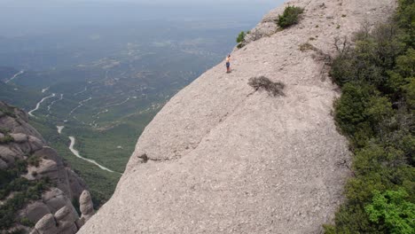 Junge-Frau-Trainiert-Auf-Dem-Gipfel-Des-Berges,-Filmische-Aufnahme-Einer-Drohne,-Die-Eine-Umlaufbahn-Durchführt,-Wellness--Und-Gesundheitskonzept,-Kloster-Montserrat,-Barcelona