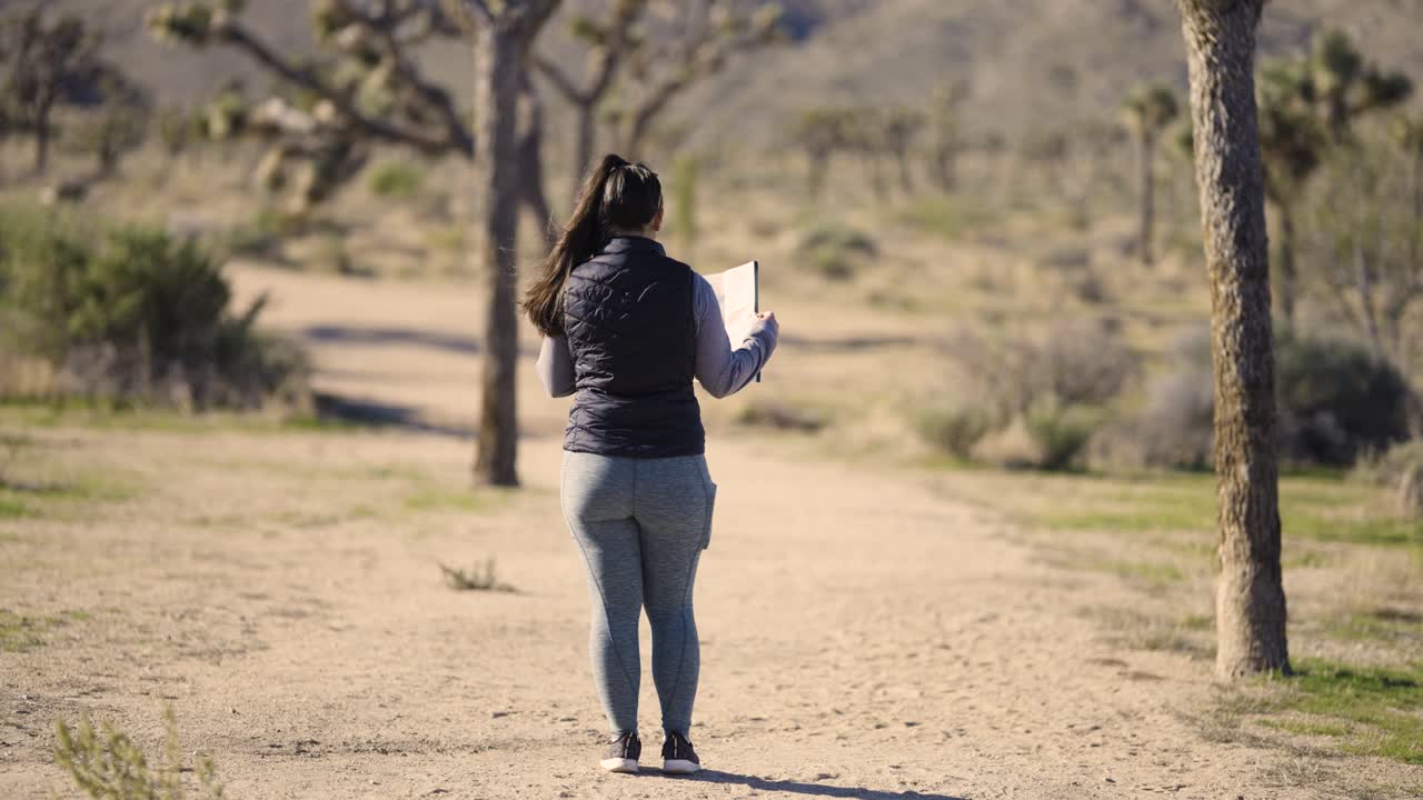 Ragazza che fotografa il deserto del Parco Nazionale Joshua Tree in California con una fotocamera Sony A1 - mentre si allontana