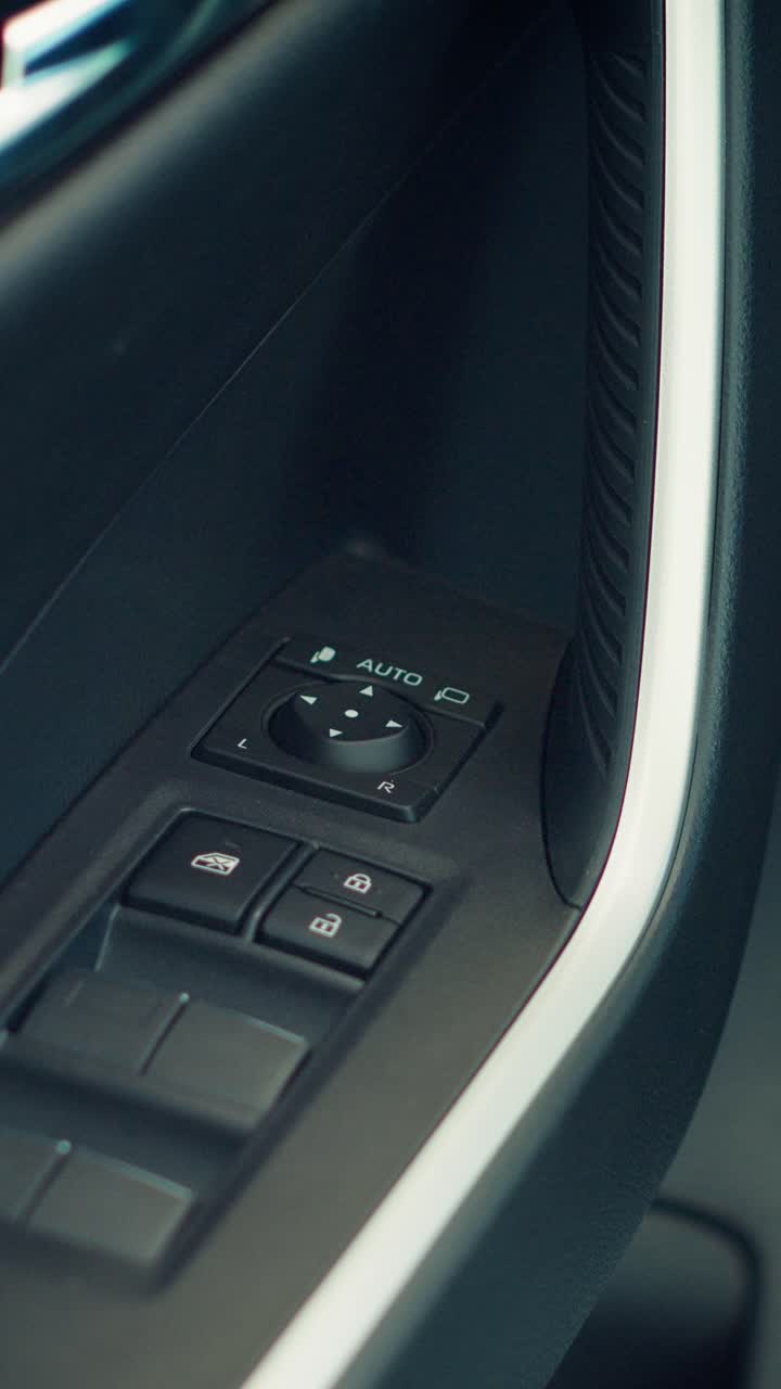 Primo piano dei comandi della portiera e degli interruttori dei finestrini di un'auto moderna.