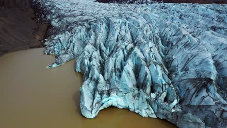 blueish glacier of svinafellsjokull between mountains in iceland