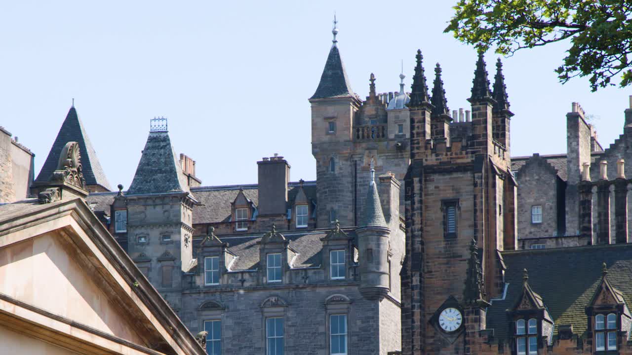 Camera slowly pans right, unveiling detailed medieval castle buildings under bright, clear daylight