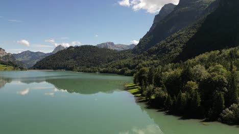 Majestic-Peaks,-Crystal-Waters:-Aerial-view-of-green-forest-and-Lakeside-Mountains