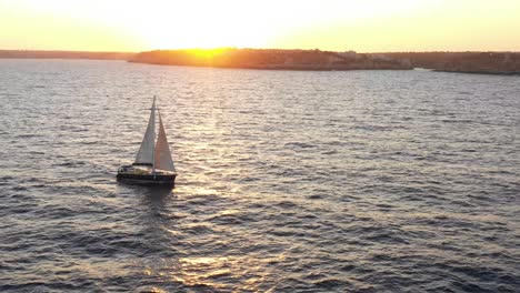 sunset view from a drone with a sail boat