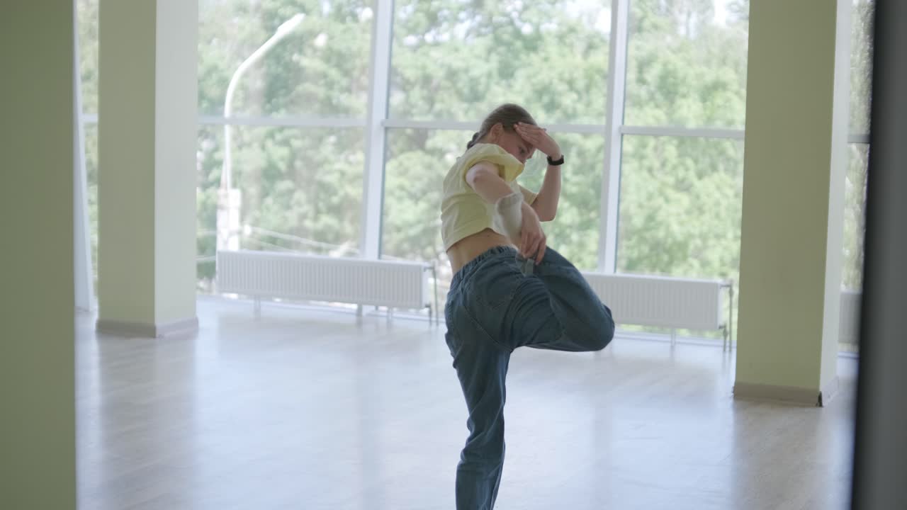 una chica joven bailando breakdance en un estudio moderno.