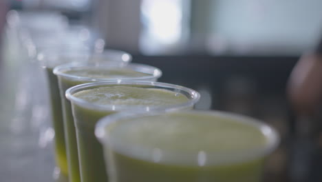 close up head on of a row of green juices