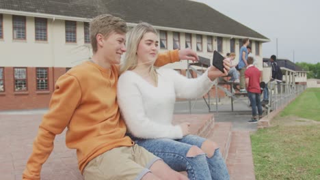 students couple taking selfie together in high school