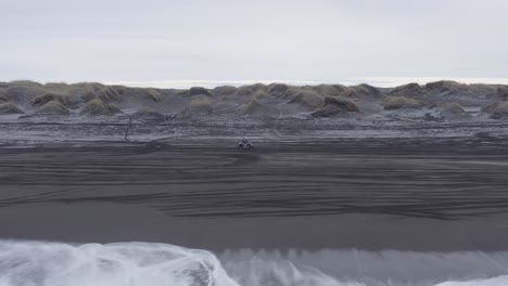 Einsamer-Quad-Biker-Fährt-Am-Malerischen-Schwarzen-Strand-Im-Kalten-Island,-LKW-Rechts