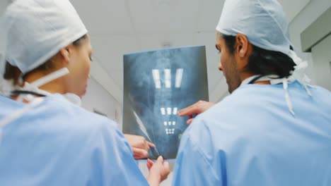 Surgeon-and-colleague-discussing-over-an-x-ray