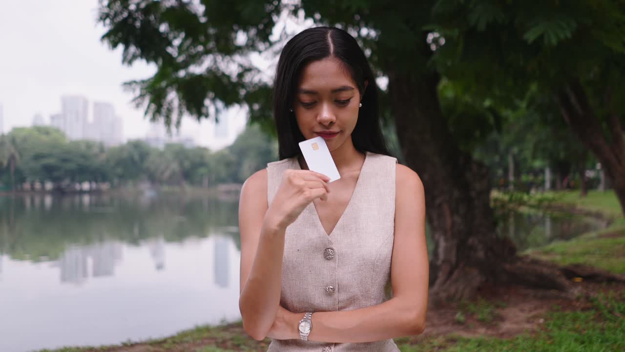 Woman using laptop and credit card in a park