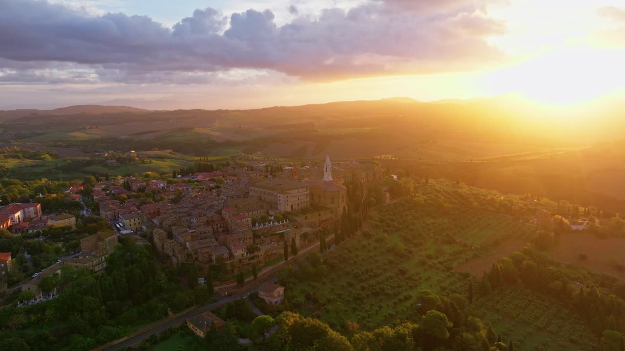 foto aérea al atardecer sobre el paisaje de la toscana con la ciudad de pienza en la cima de la colina, provincia de siena, italia