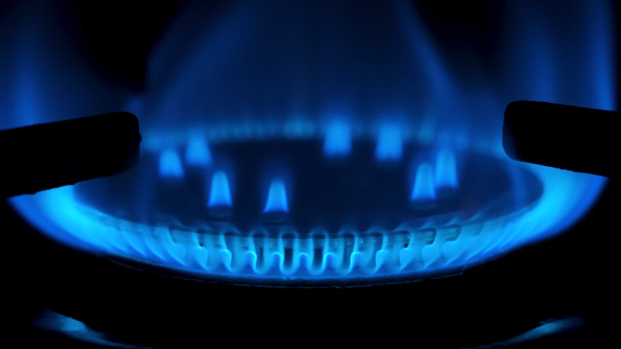 검은 바탕에 고립 된 가스 스토브를 켜고 있습니다. 천연 가스 적자 개념. 4k 해상도 비디오