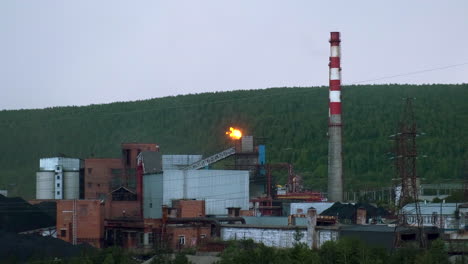 промышленное предприятие с пламенем и дымовыми трубами