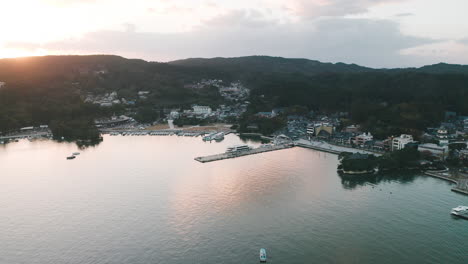 boats and ferry docked at the marina and pier in matsushima bay, fukuura island, miyagi, japan at sunset