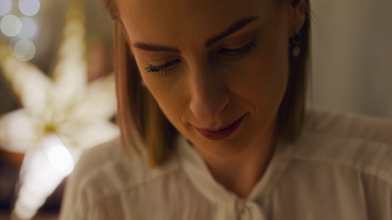 mujer en la sala de estar prepara decoraciones y arregla luces de navidad